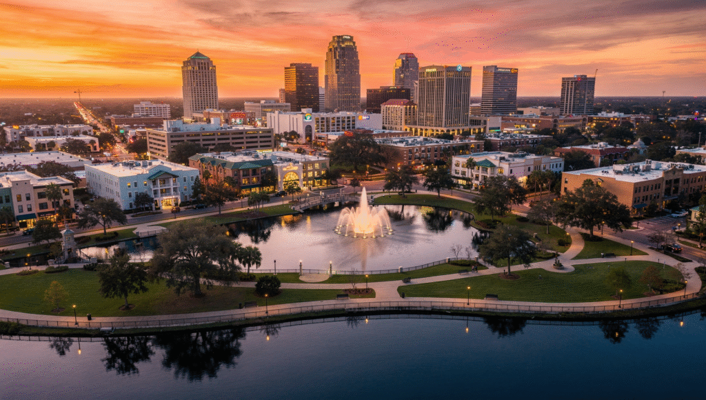 Aerial view of downtown Orlando skyline with Lake Eola in the foreground at sunset, walking paths, fountains, and surrounding neighborhoods, high quality real estate photography